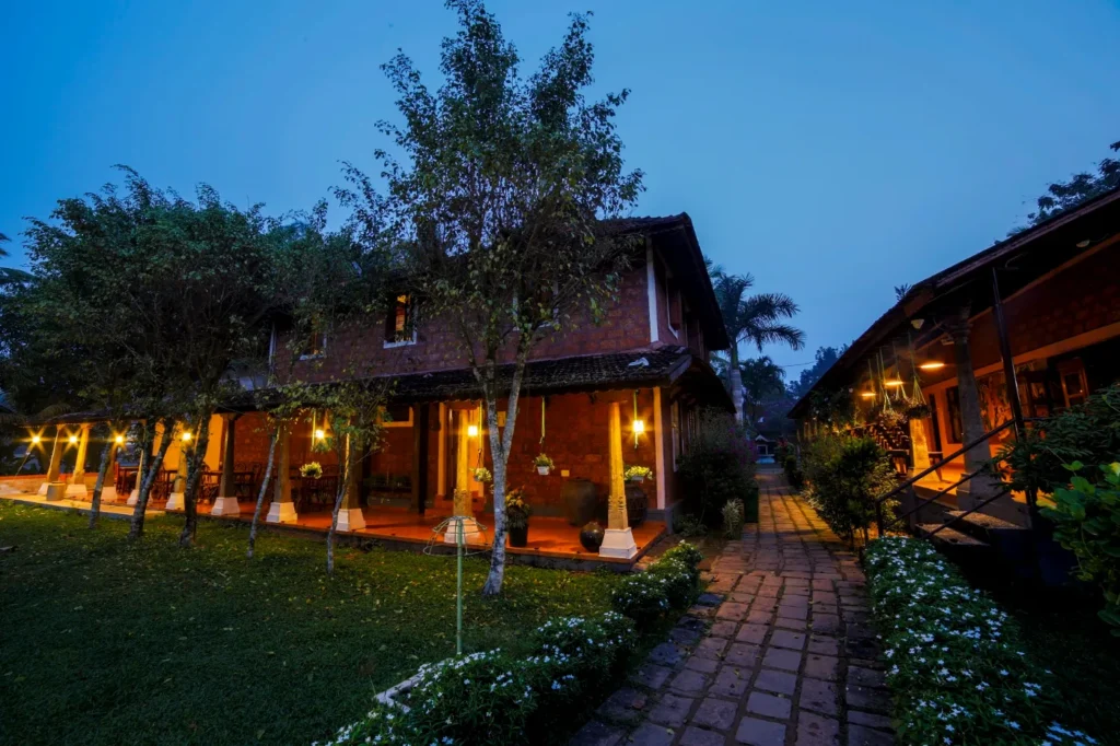 Cottages at Athreya Ayurvedic Centre, Kottayam, with lamps lit at twilight