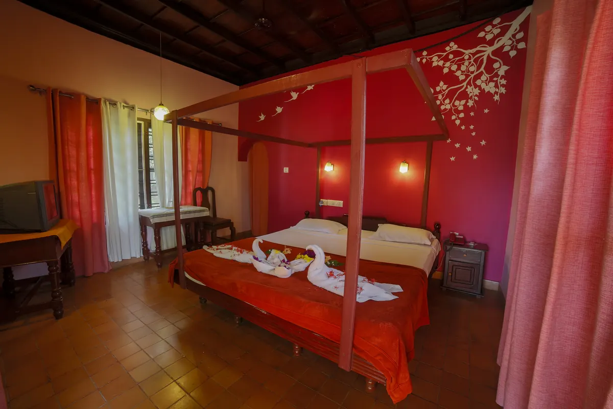 Guest room with a four-poster bed at Athreya Ayurvedic Centre